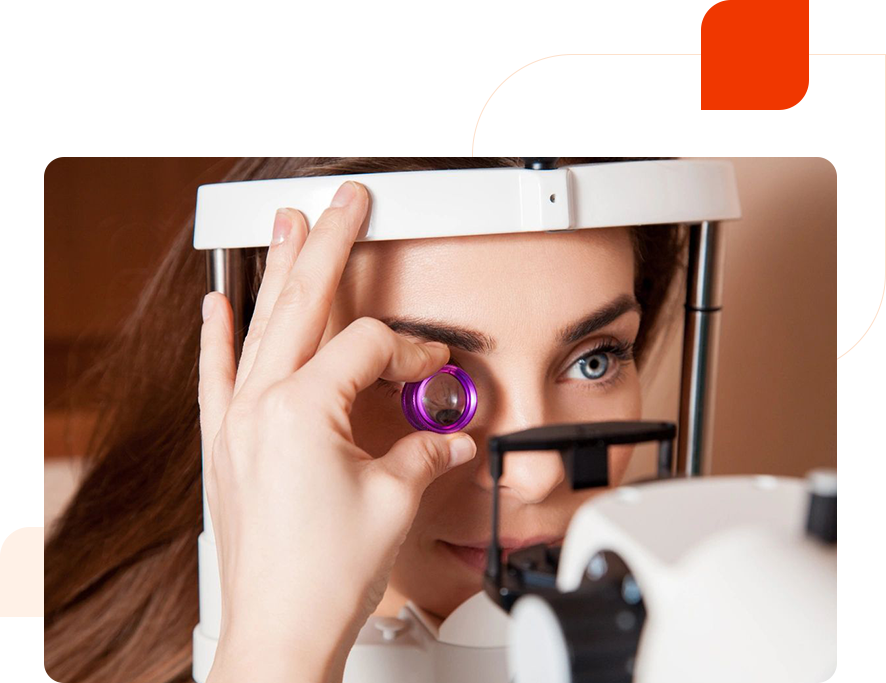 A woman looking through the lens of an eye test machine.