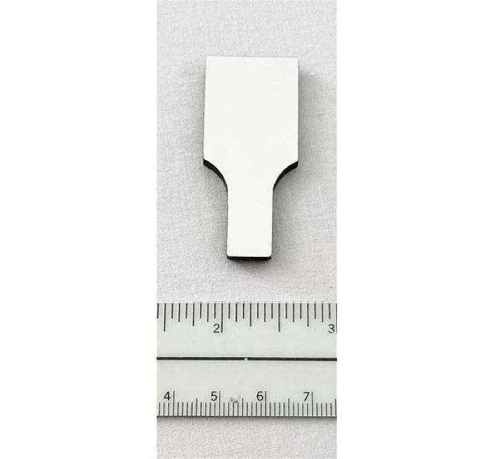 A white metal object with a ruler and centimeter